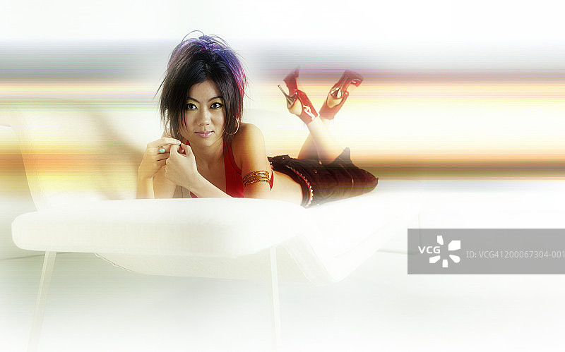 年轻女人俯卧在沙发上图片素材