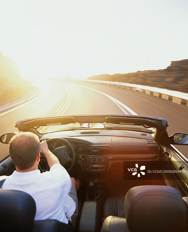 男人在高速公路上驾驶敞篷车，后视图图片素材