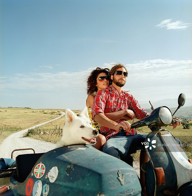 乡村公路骑摩托车的情侣，边斗里有狗图片素材