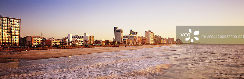 日出时海岸线沿线的建筑物图片素材