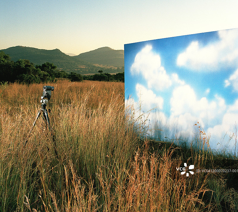 三脚架上的摄像机，乡村云彩画作图片素材