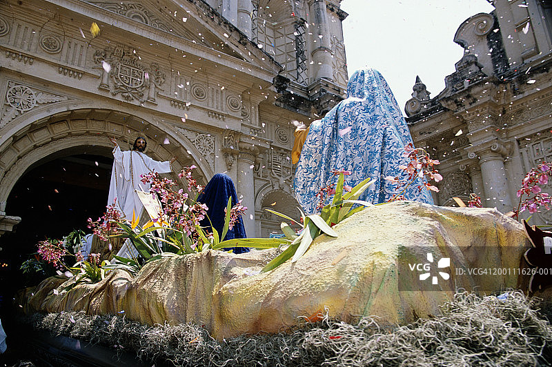 两个女人在教堂前观看耶稣雕像（后视图）图片素材