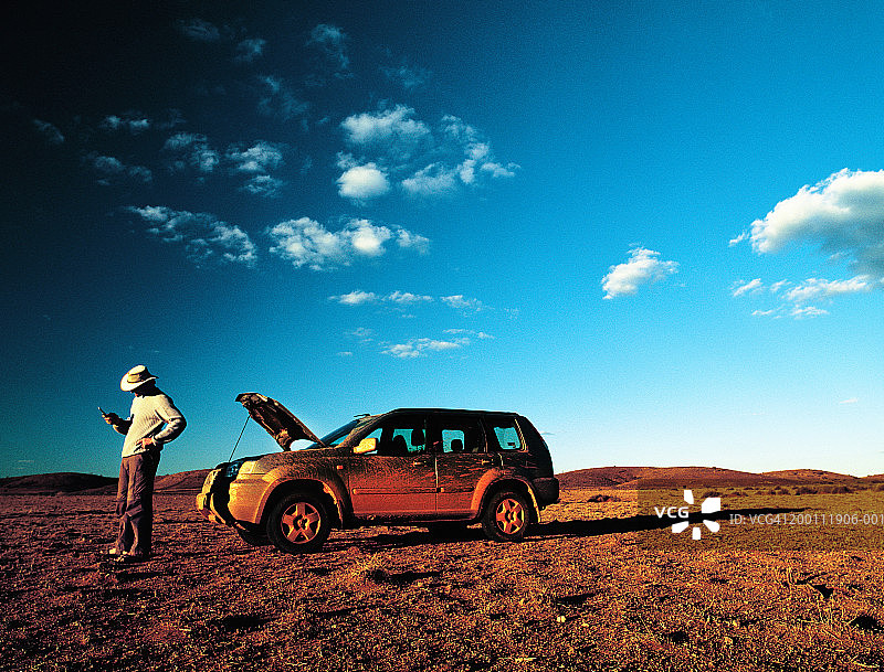 在4x4旁使用手机的男人图片素材
