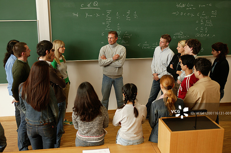 课堂上围绕讲师和黑板的学生们图片素材
