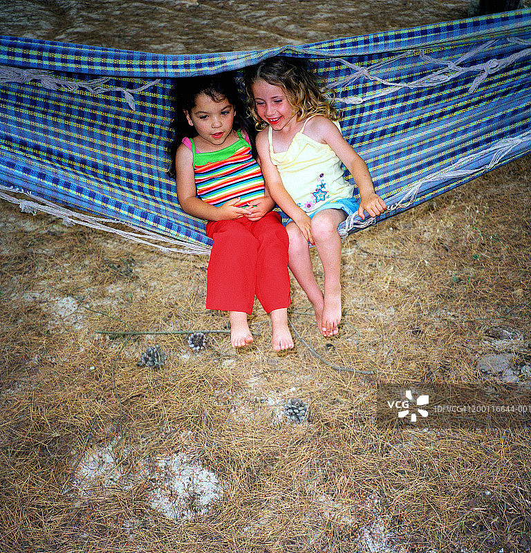 在吊床上玩耍的两个女孩（3-5岁），高角度拍摄图片素材
