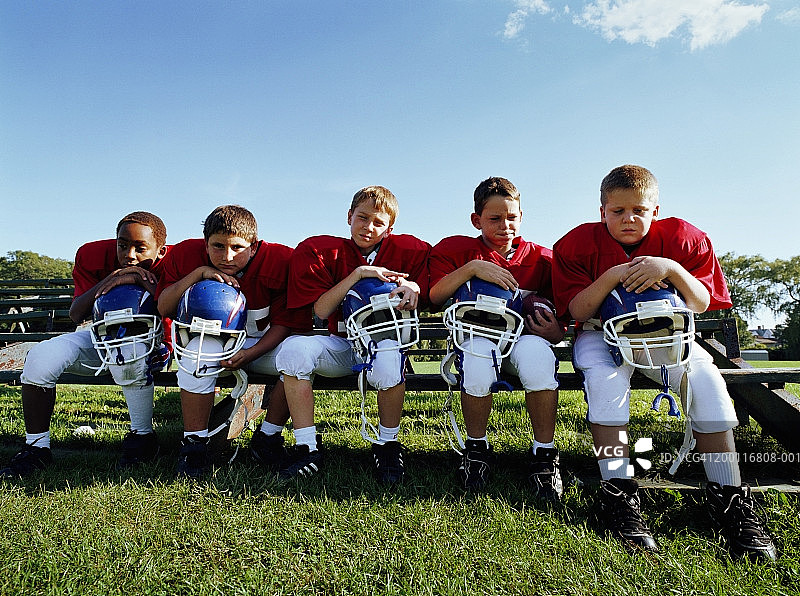 靠在头盔上的小足球运动员（8-10岁）图片素材