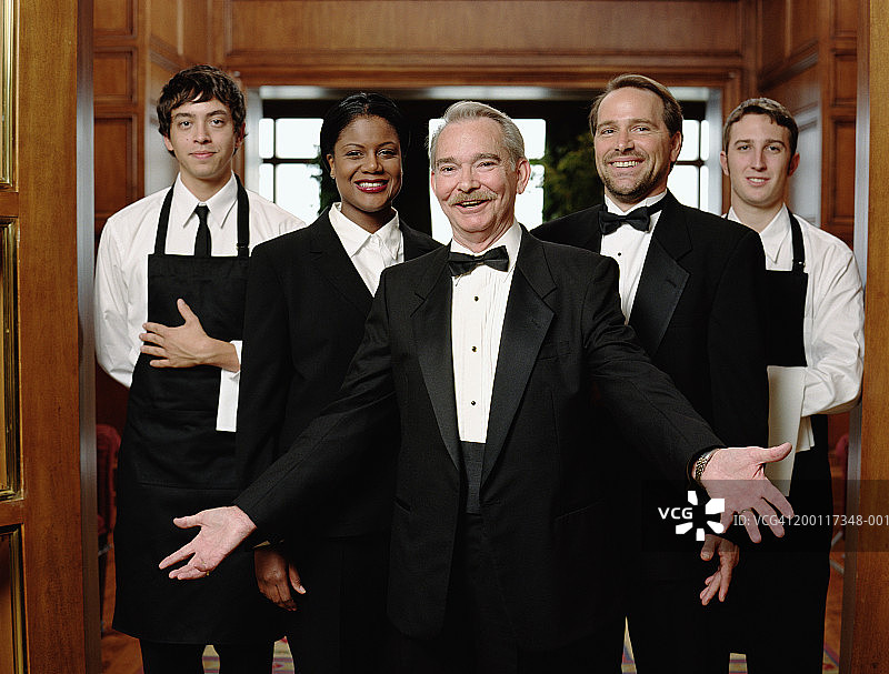 身穿燕尾服的餐厅服务员站在员工前图片素材