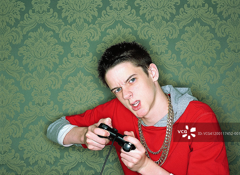 正在玩电脑游戏手柄的男孩（14-16岁）肖像图片素材