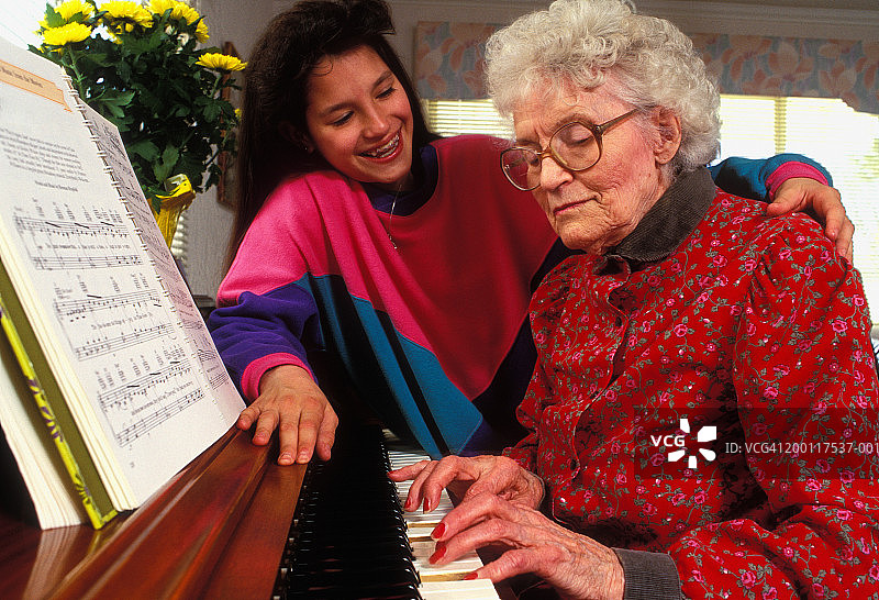 孙女(12-14岁)看奶奶弹钢琴图片素材