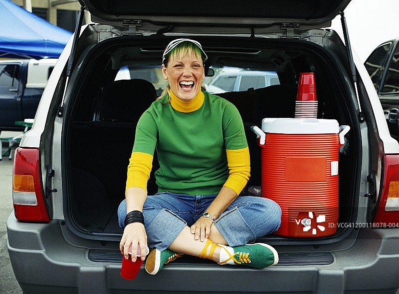 女人坐在汽车后座，旁边放着饮水机图片素材
