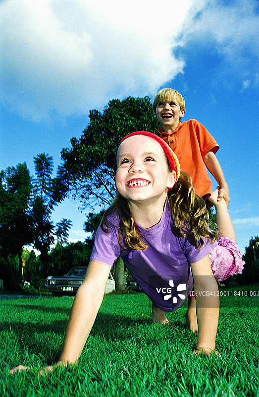 在花园里玩耍的男孩（7-9岁）和女孩（5-7岁）特写图片素材