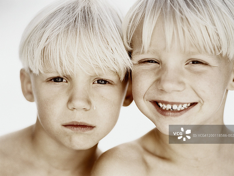 一对双胞胎兄弟（6-8岁），一个在微笑的特写肖像图片素材