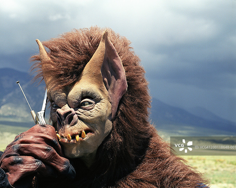 穿着怪物服装使用手机的男人特写图片素材