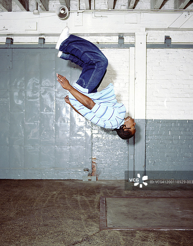 年轻男人做后空翻，侧视图图片素材