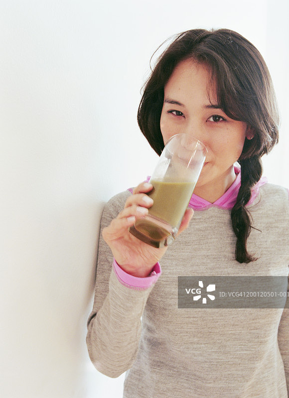 女人喝小麦草饮料肖像照图片素材