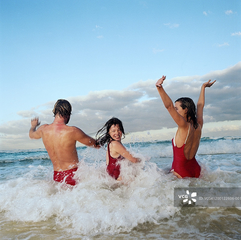 女孩和父母在海边玩耍图片素材