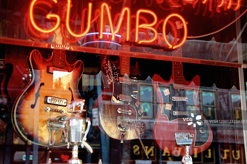 霓虹灯招牌的吉他店橱窗倒影图片素材