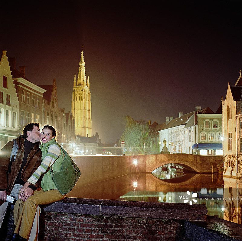 比利时弗兰德斯布鲁日桥墙上的情侣，夜晚图片素材