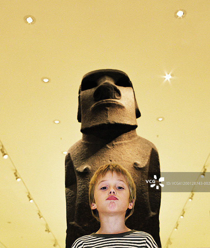 模仿雕像表情的男孩（7-9岁），肖像图片素材