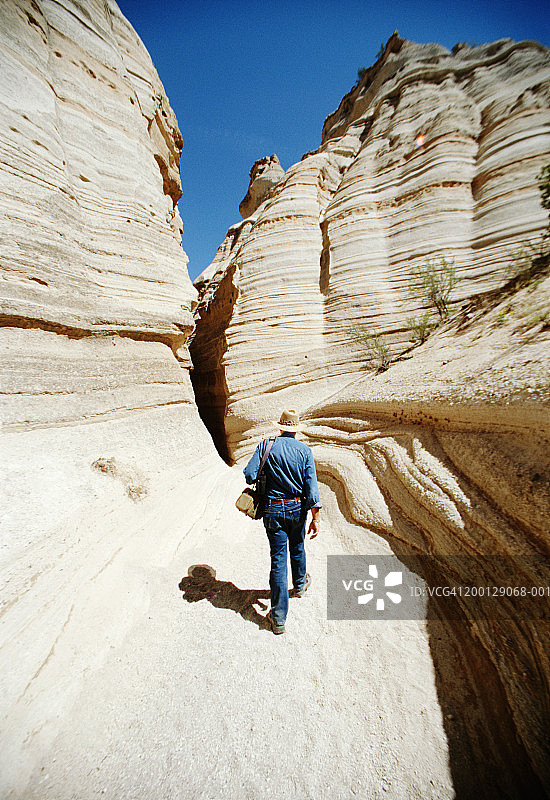 在岩石上徒步的男人（后视图）图片素材