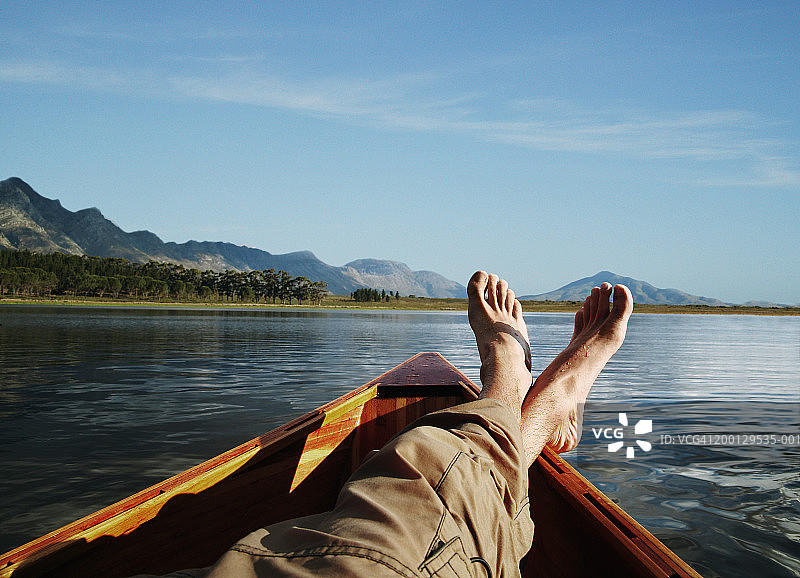 躺在湖上小船里的年轻男人图片素材