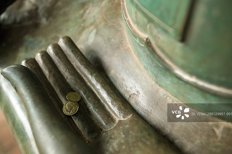 老挝琅勃拉邦西萨格寺佛像手中的硬币图片素材