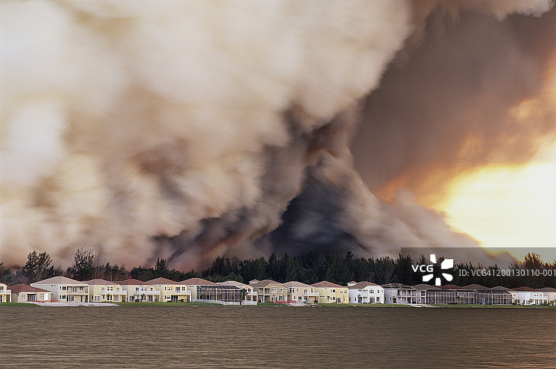 湖畔住宅后方的森林火灾图片素材