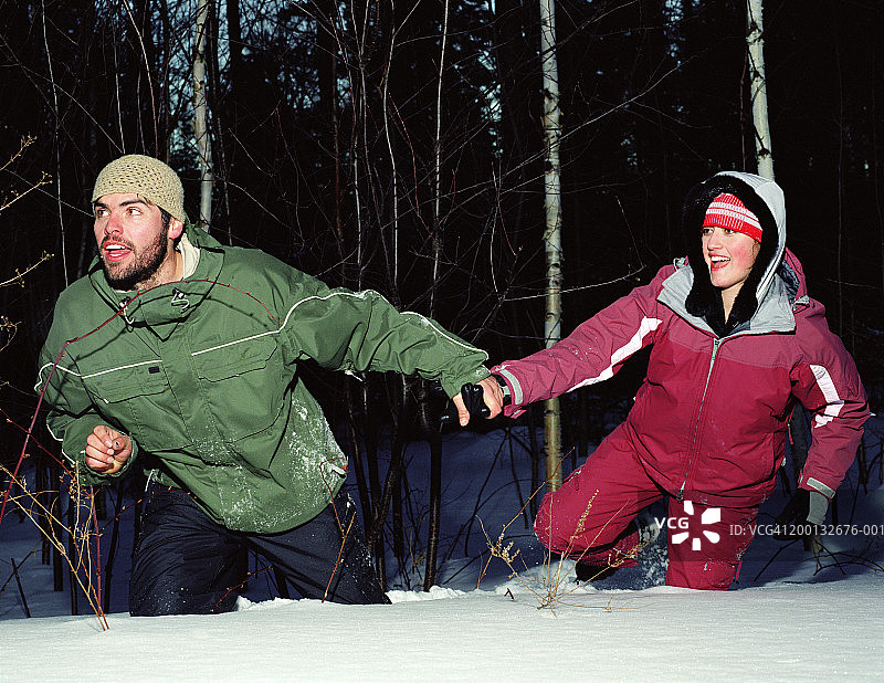 男人拉着女子穿过厚厚的积雪图片素材