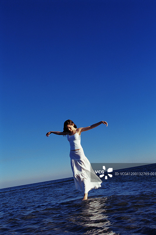 张开双臂、走在海面上的少女（15-17岁）图片素材