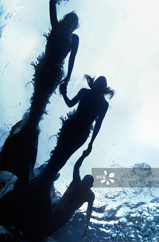 水下牵手的“美人鱼”和“男人鱼”，低角度视角图片素材
