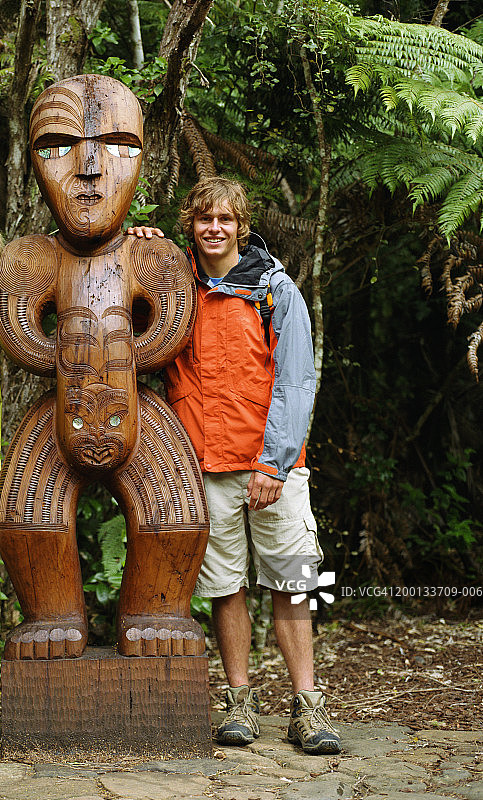 年轻人站在祖先守卫柱旁，肖像图片素材