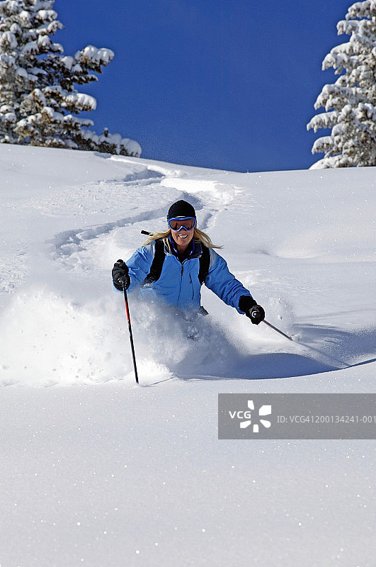 滑雪的女人从斜坡滑下图片素材