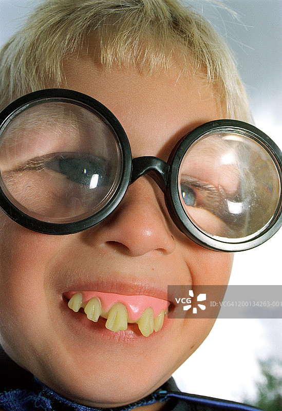 特写：男孩（5-7岁）戴着假牙和滑稽的眼镜图片素材