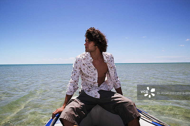 坐在海上划艇向侧面看的年轻人图片素材