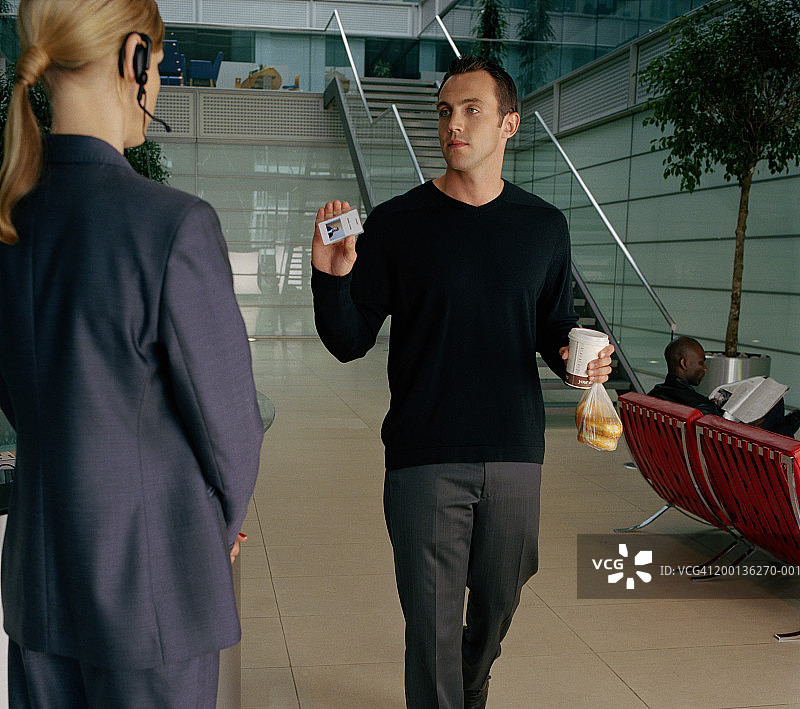 男人向女保安出示身份证图片素材