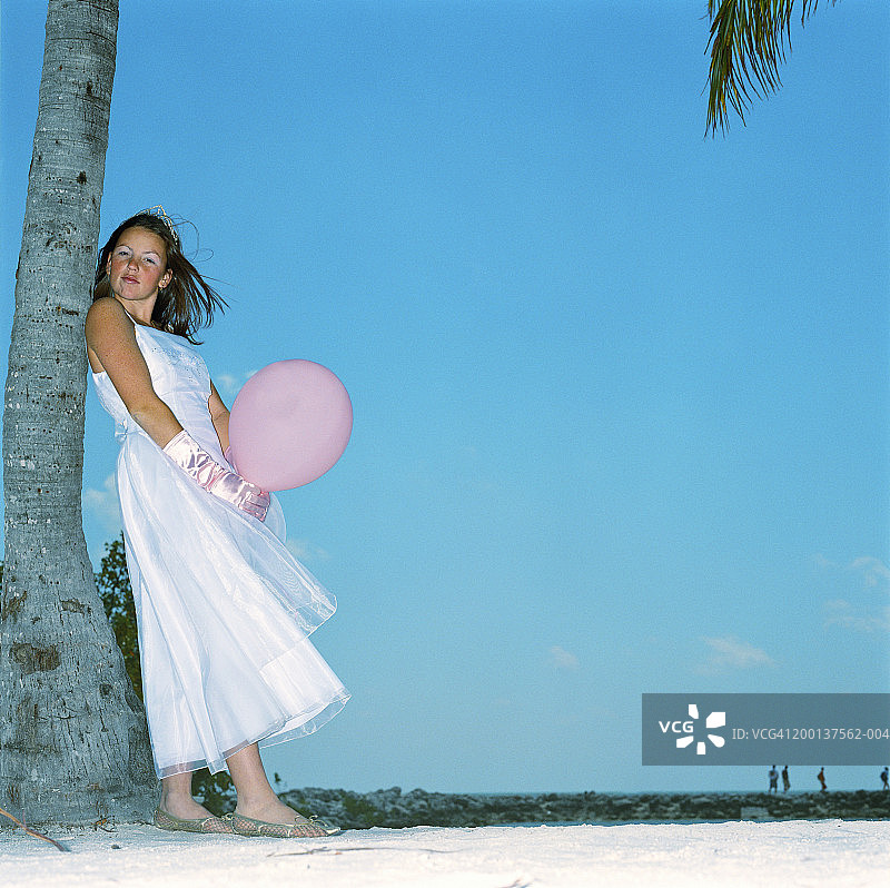 少女身穿正装在沙滩手持气球肖像图片素材