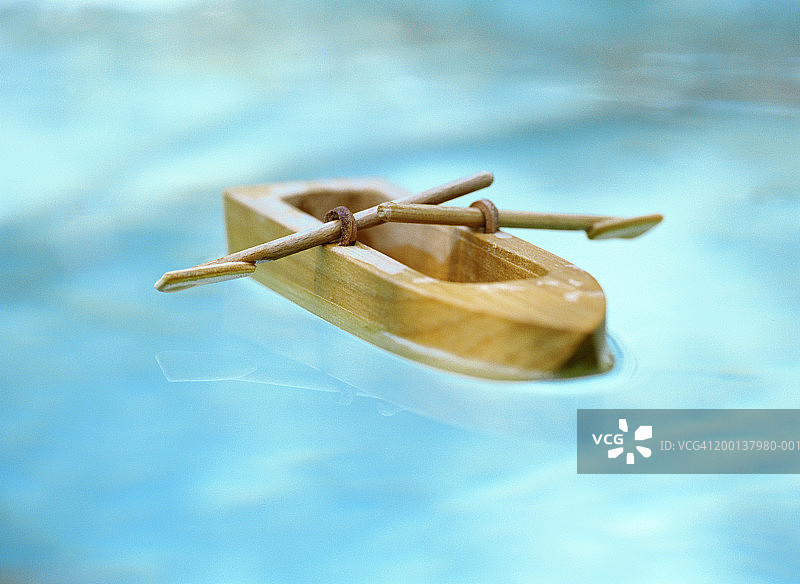 水中漂浮的木制玩具船特写图片素材