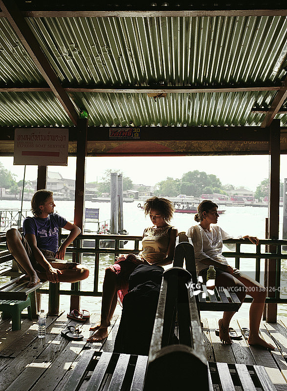 泰国曼谷Tha Thien码头湄南河畔的三个人图片素材