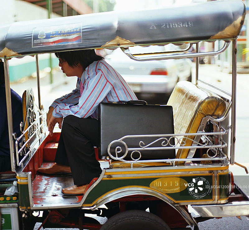 在开放式出租车内的商务人士（侧视图）图片素材