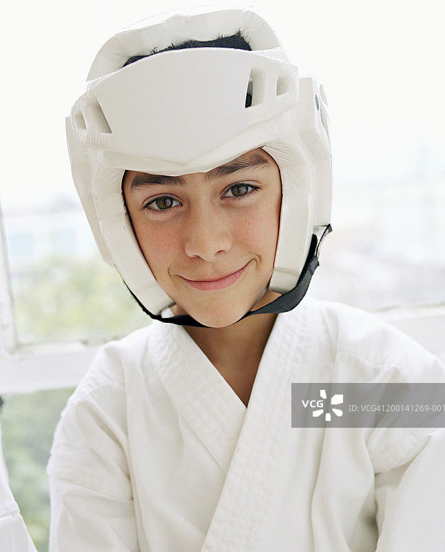 男孩（9-11岁）戴着防护头盔，身穿跆拳道服图片素材