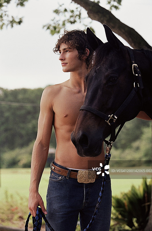 赤膊青年牵着马的缰绳，春天图片素材