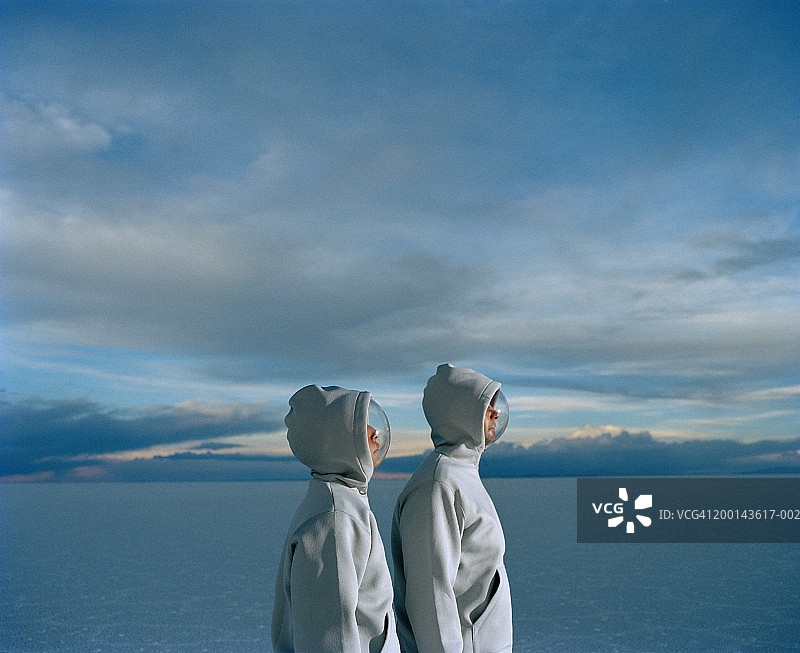 年轻夫妇穿着防护服和面罩，侧视图图片素材