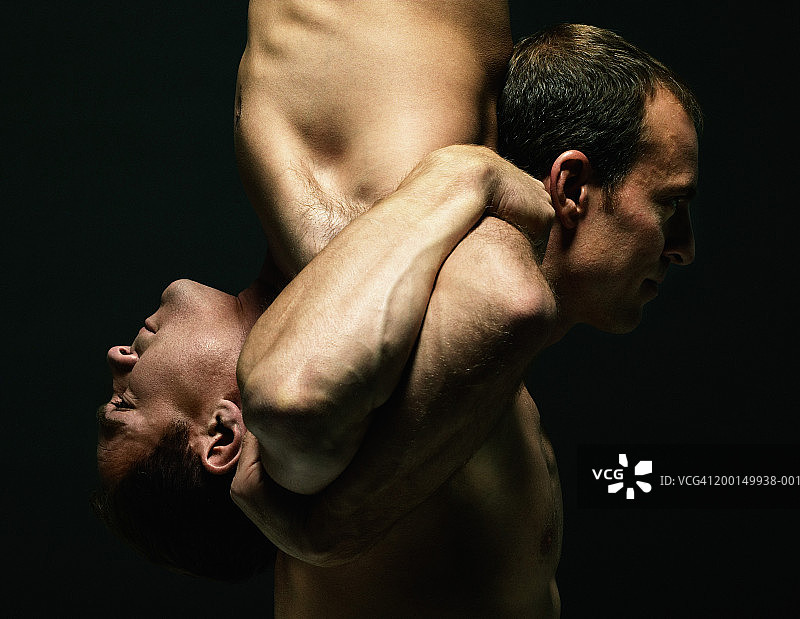 两个男人手挽着手表演平衡，侧视特写图片素材