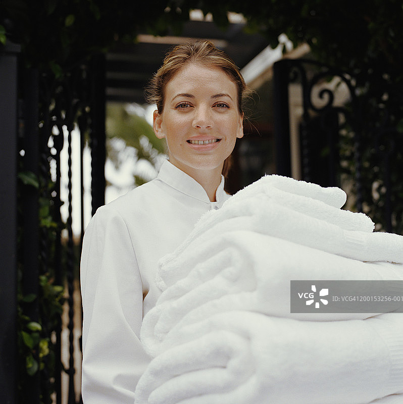 客房服务员拿着一叠毛巾的肖像图片素材