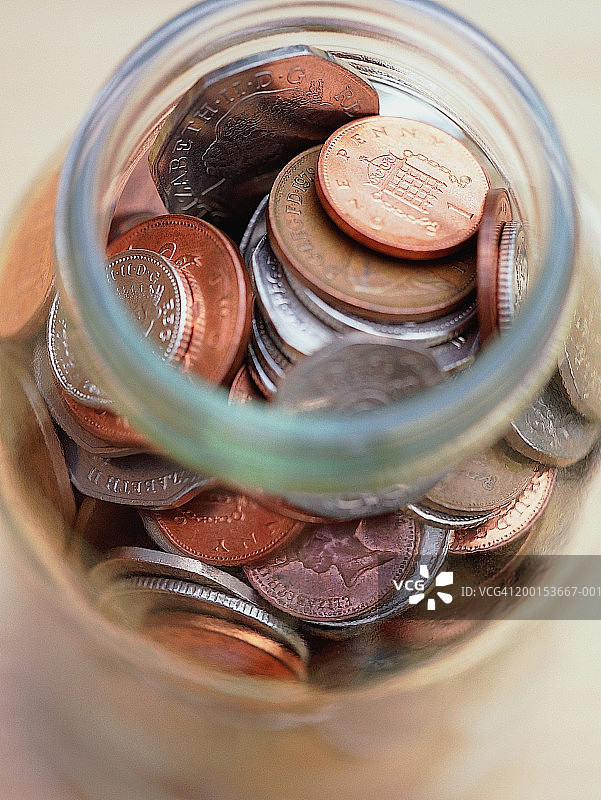 英国货币：装满各种硬币的罐子，特写图片素材