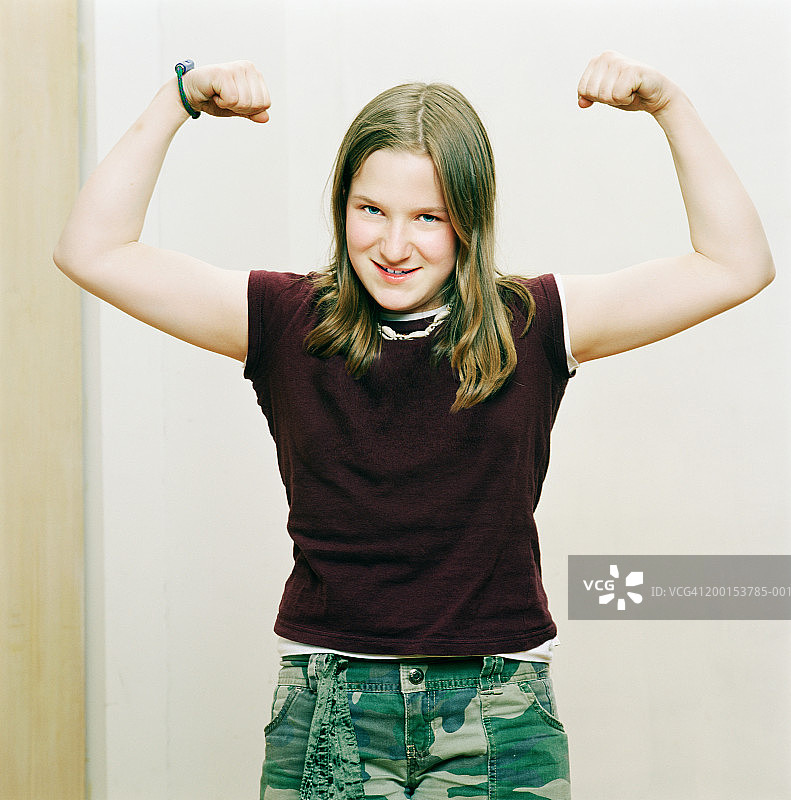展示手臂肌肉的少女（12-14岁）图片素材