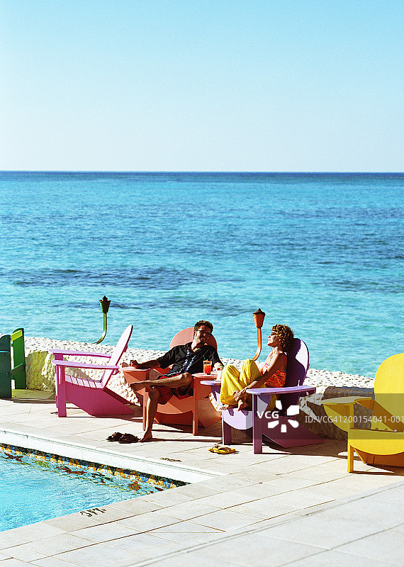 在泳池边躺椅上的情侣图片素材