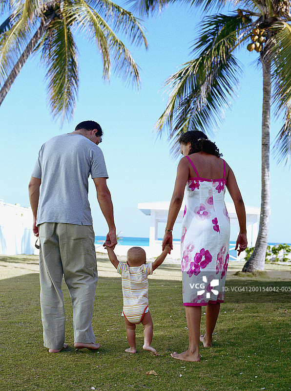 父母带着宝宝（12-14个月）走路的背影图片素材