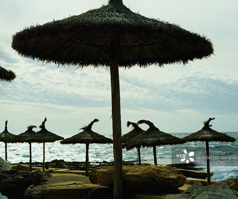 西班牙马略卡岛圣乔迪亚殖民地的海滩茅草伞图片素材