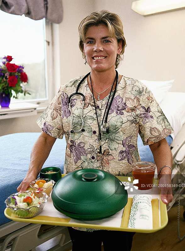 护士在病房里端着食物托盘图片素材